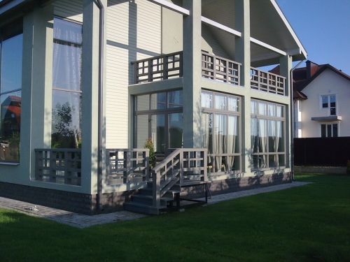 Огородження з дерева, пофарбовані в сірий колір, підкреслюють елегантність і шик екстер'єру будинку